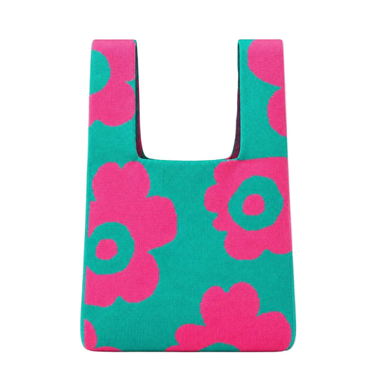 A reusable tote bag with a bold pink and teal floral pattern, shown against a light gray background.