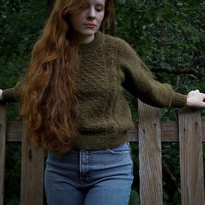 Woman posed in dark green pullover with textured front