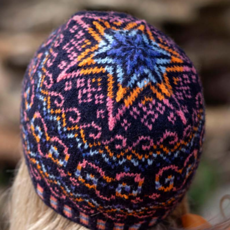 Completed knitted hat with star on top and sea wave style patterns around it